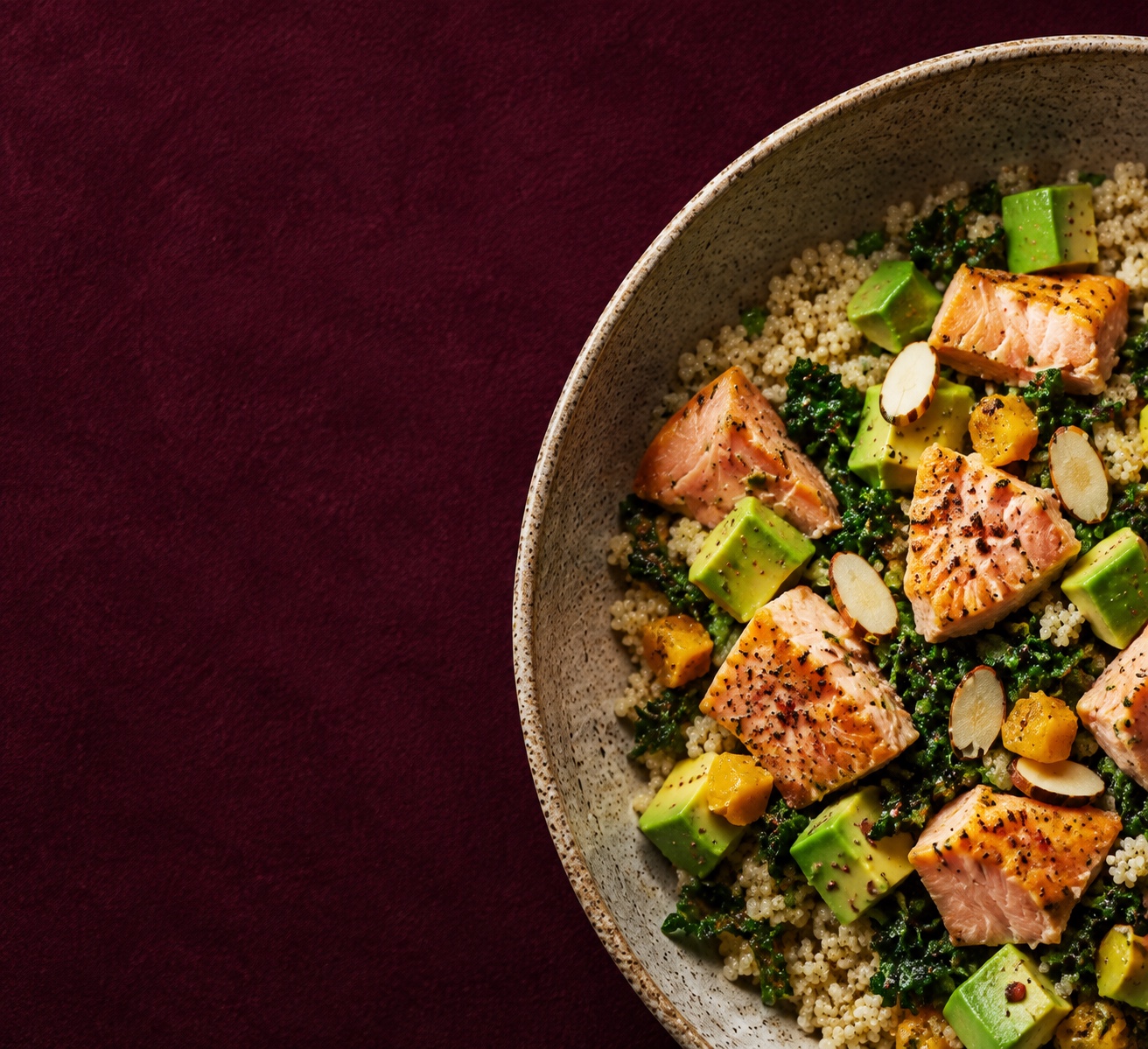 Salmon, avocado, quinoa and greens in a ceramic bowl